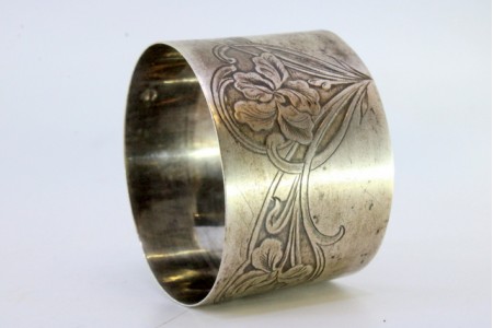 Argola de guardanapo em prata com relevos florais gravados.